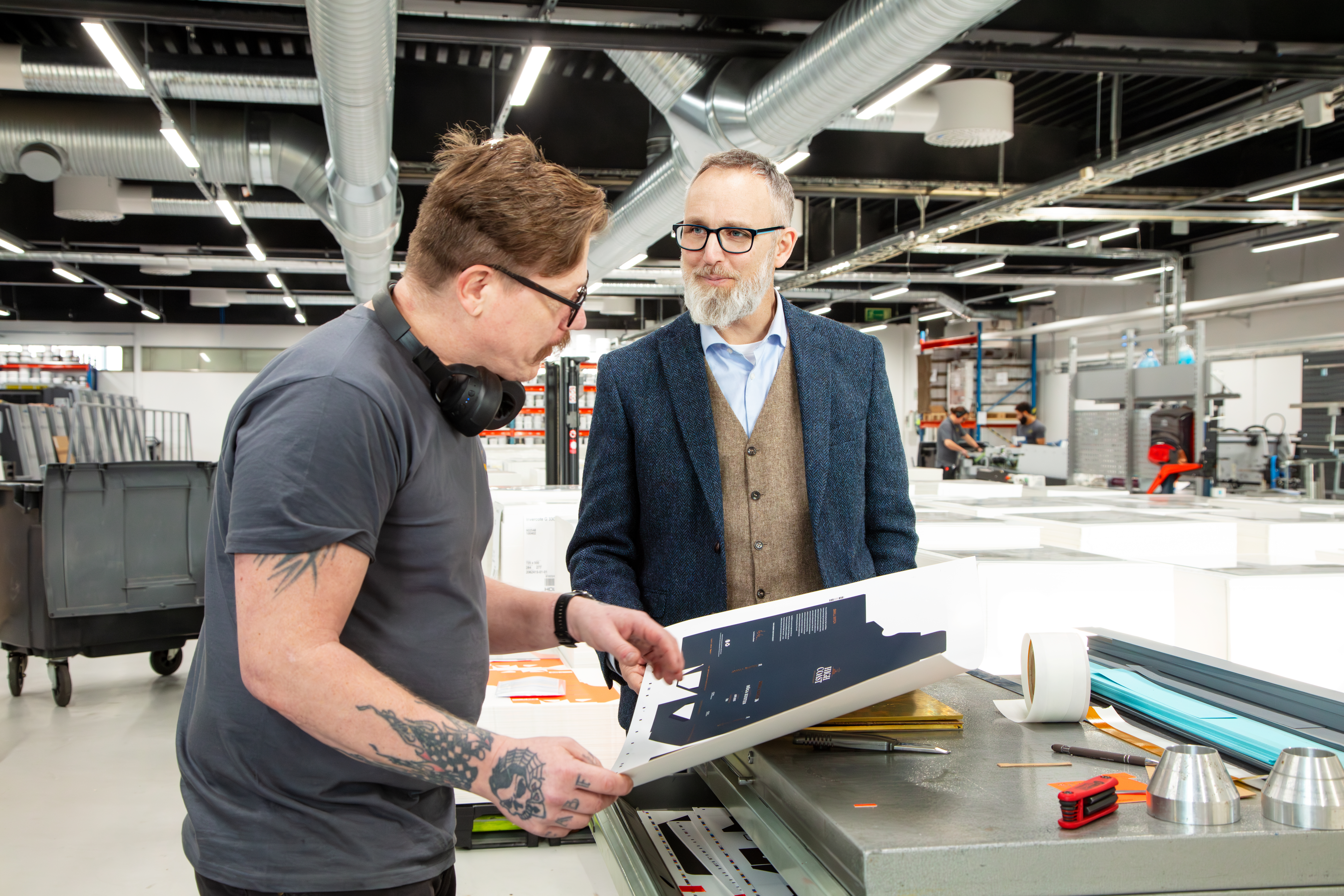 Bild på vd Erik Blix i samspråk med maskinoperatören Mattias Jensen.